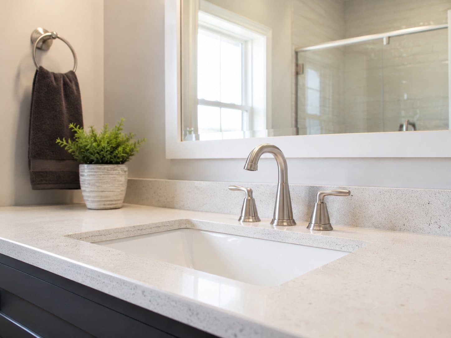 A finished bathroom with a new brushed-nickel faucet and clean quartz vanity